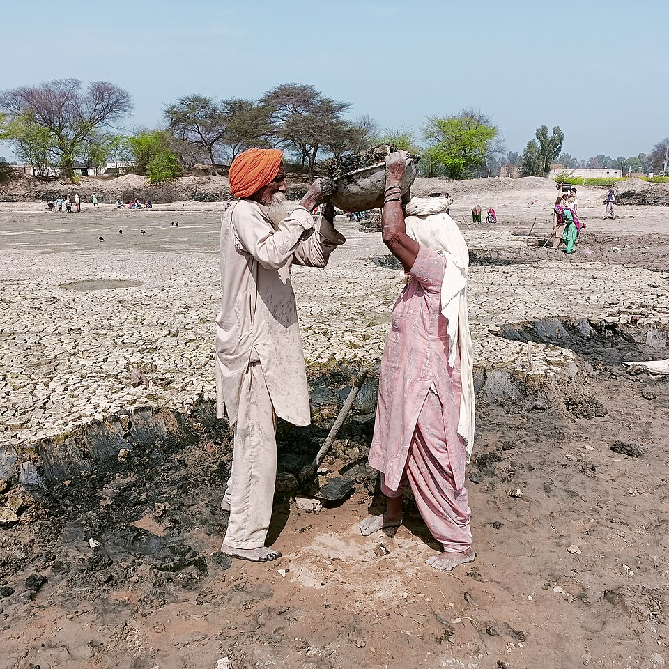 MGNREGA workers removing mud from a dry pond